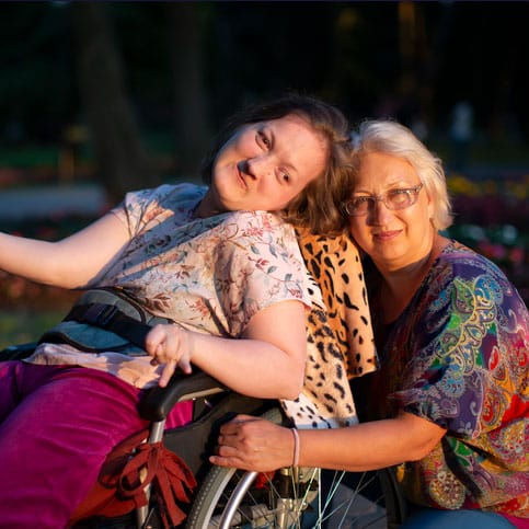 caretaker and adult with downs in wheelchair
